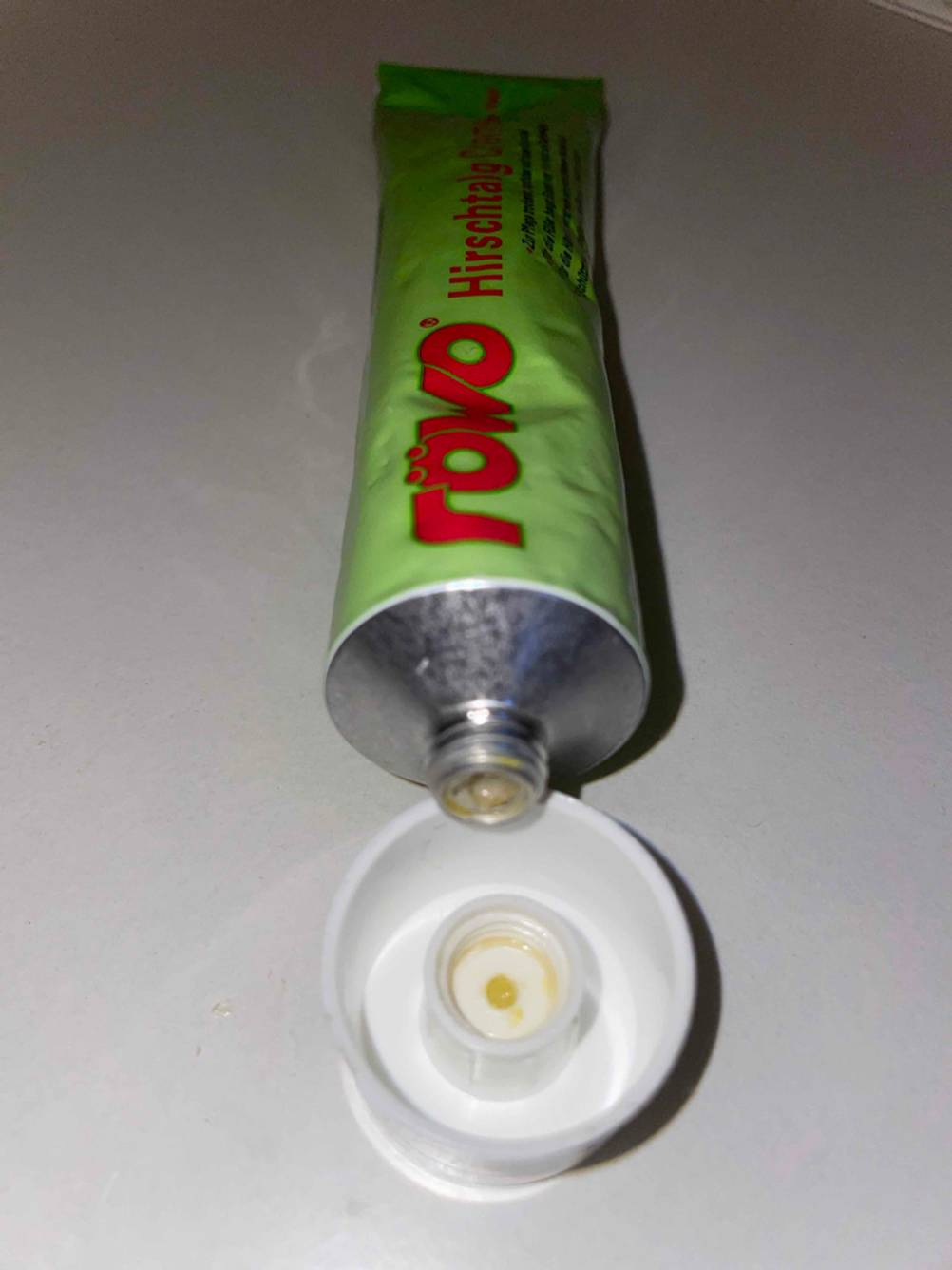 Eine geöffnete Tube der Hirschtalgcreme im Test liegt auf ihrer Kappe.