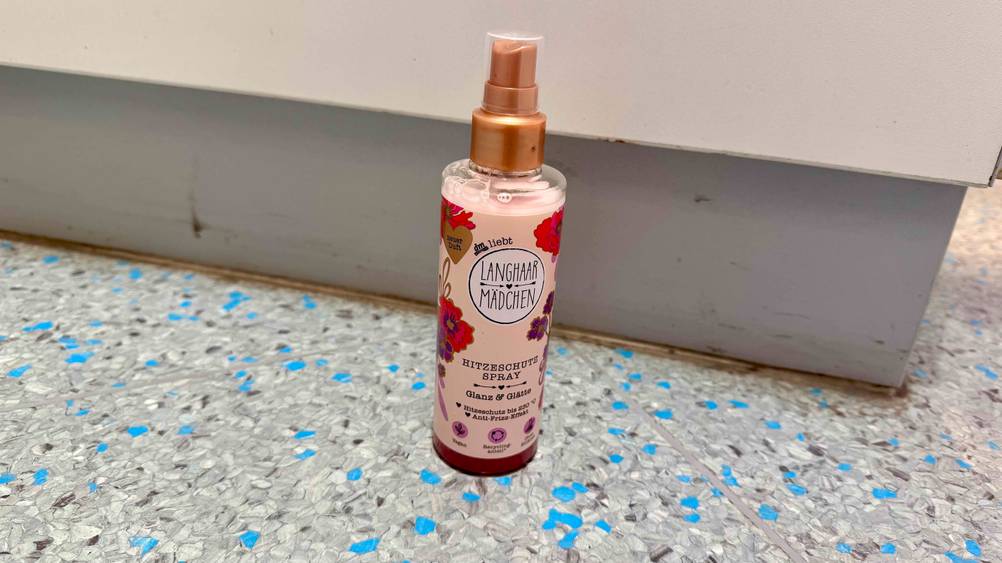 Hitzeschutzspray im Test: Eine Flasche von schräg oben auf dem Boden stehend.