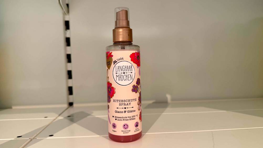 Ein getestetes Hitzeschutzspray steht in einem weißen Regal.