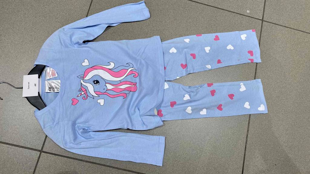 Im Test: Ein Pyjama für Kinder mit Einhornmotiv liegt auf einem Fliesenboden.