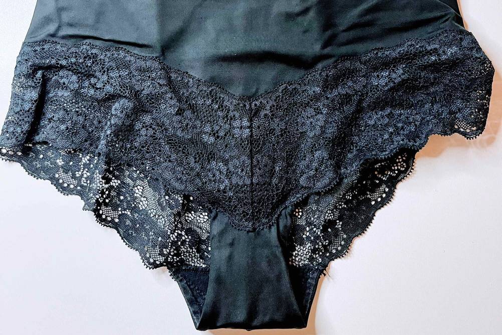 Shapewear für Damen im Test: Eine schwarze Hose mit Rüschen liegt auf weißer Fläche.