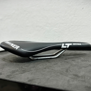 Der HNVNER-Fahrradsattel ist in der Seitenansicht zu sehen. Der Übergang von Polsterung zu Streben ist gut sichtbar.