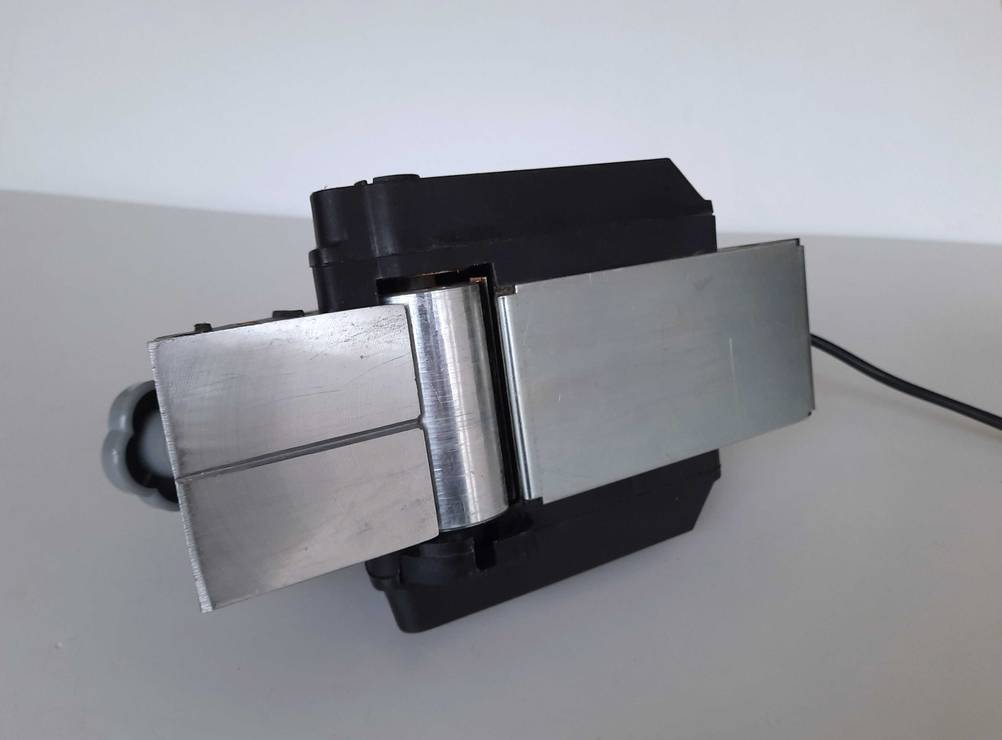 Eine getestete Hobelmaschine in Nahaufnahme von unten mit Hobelfläche auf einer hellen Oberfläche.