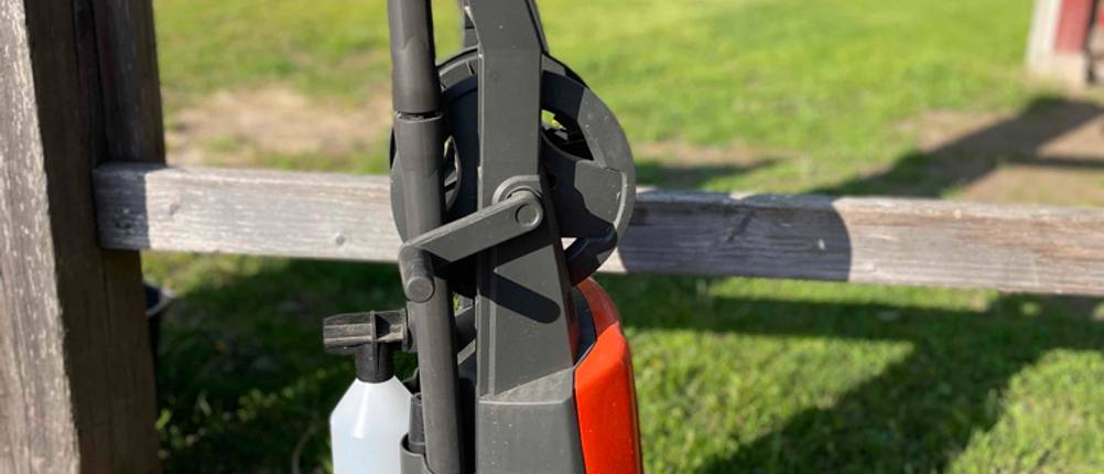 Hochdruckreiniger getestet: Ein Gerät von der Seite vor einem Holzzaun.