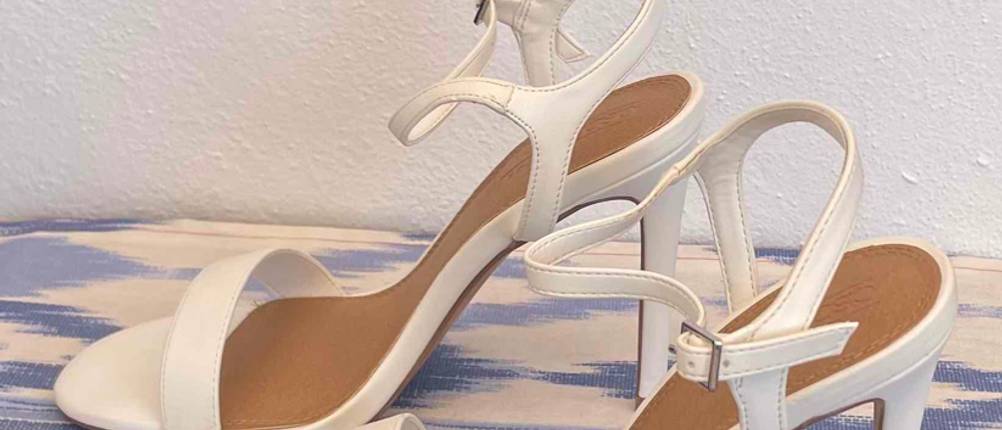 Weiße Hochzeitsschuhe im Test befinden sich auf dem Boden. 