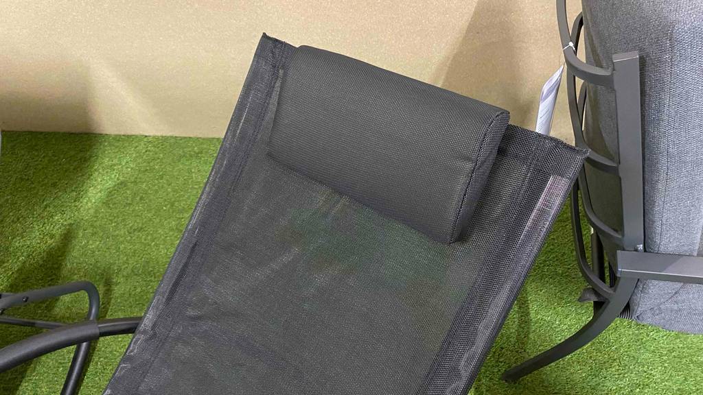 Schaukelliegen im Test: Detailansicht des Kopfkissens einer schwarzen Schaukelliege mit schwarzem Gestell im Verkaufsbereich.