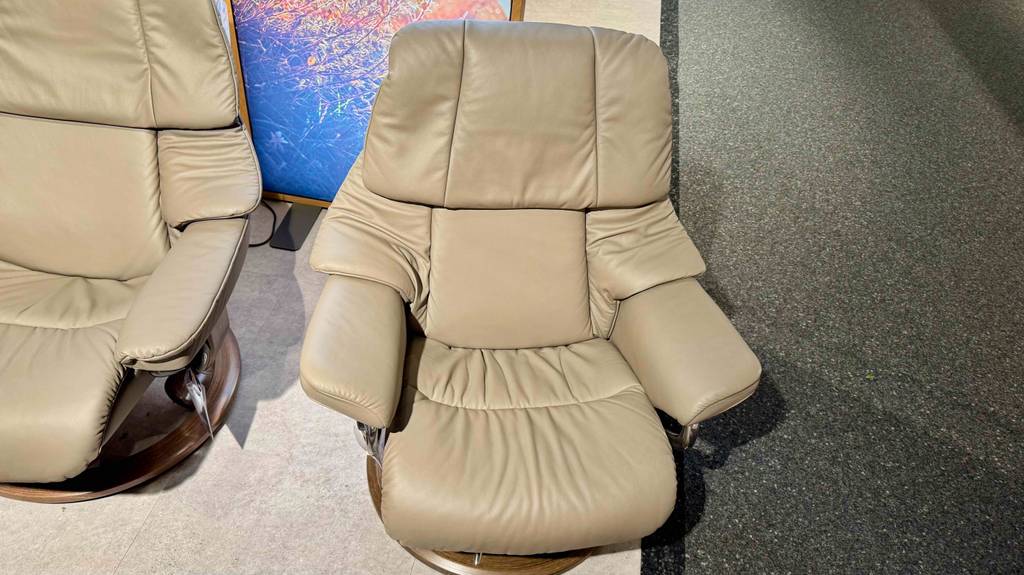 Ansicht von oben auf einen getesteten Relaxsessel mit Hocker in beigefarbenem Design, der in einem Möbelgeschäft steht.