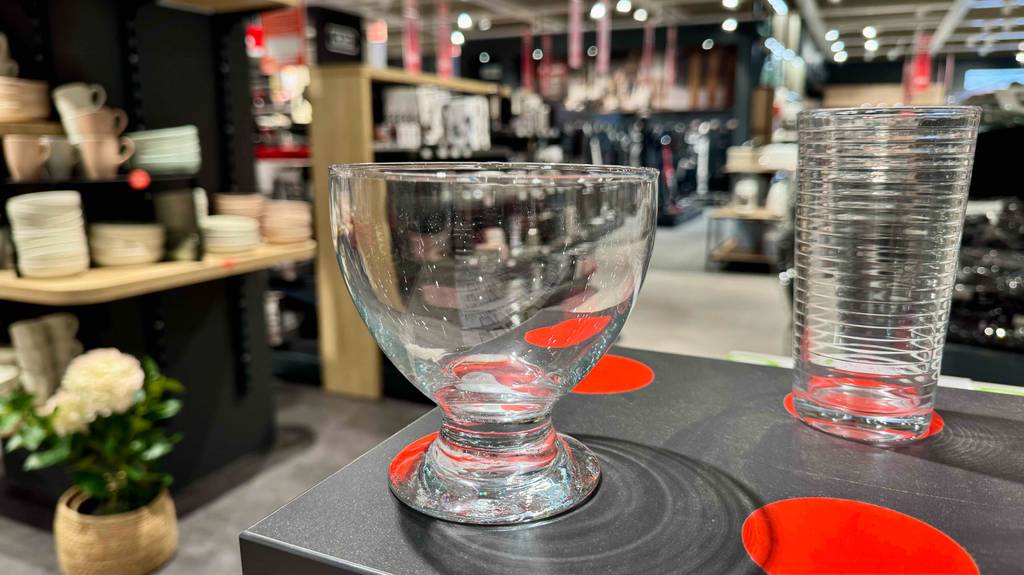 Getestete Dessertgläser: Das bauchige Glas steht neben einem Trinkglas auf einem Ausstellungstisch im Verkaufsbereich.