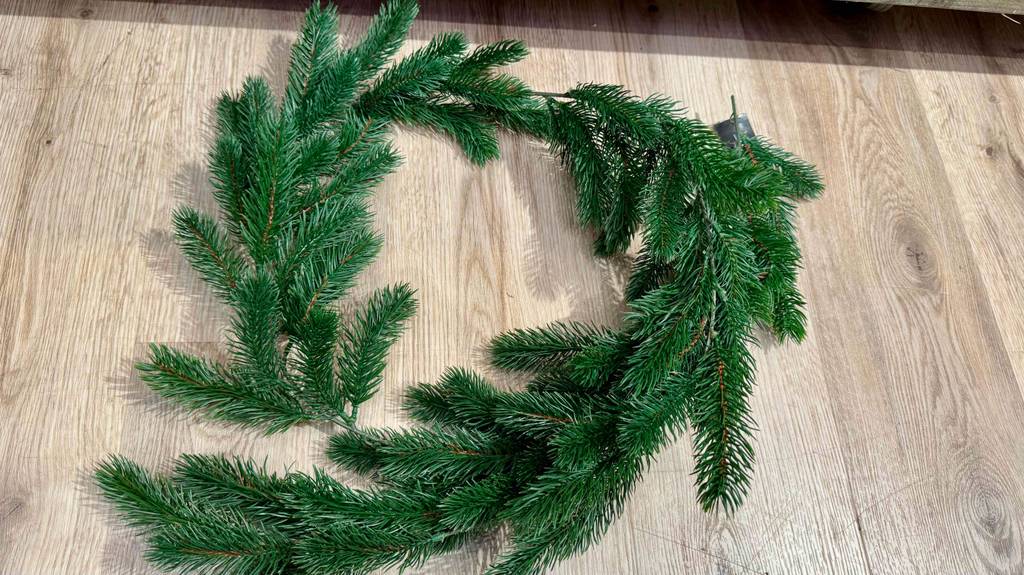 Weihnachtsgirlanden im Test: Blick von oben auf eine Girlande, die auf einem Holzboden liegt.