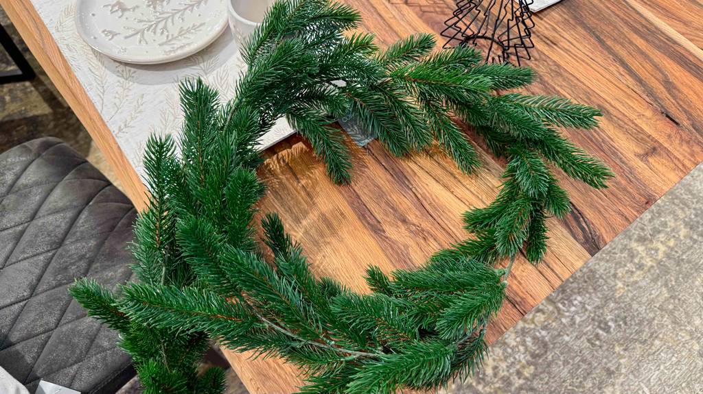 Eine getestete Weihnachtsgirlande liegt auf einem Holztisch.