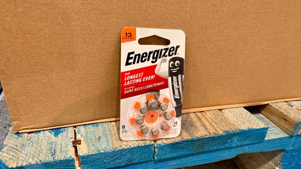Eine Packung der getesteten Hörgeräte-Batterien-13 vor einem Karton auf einer Holzpalette.