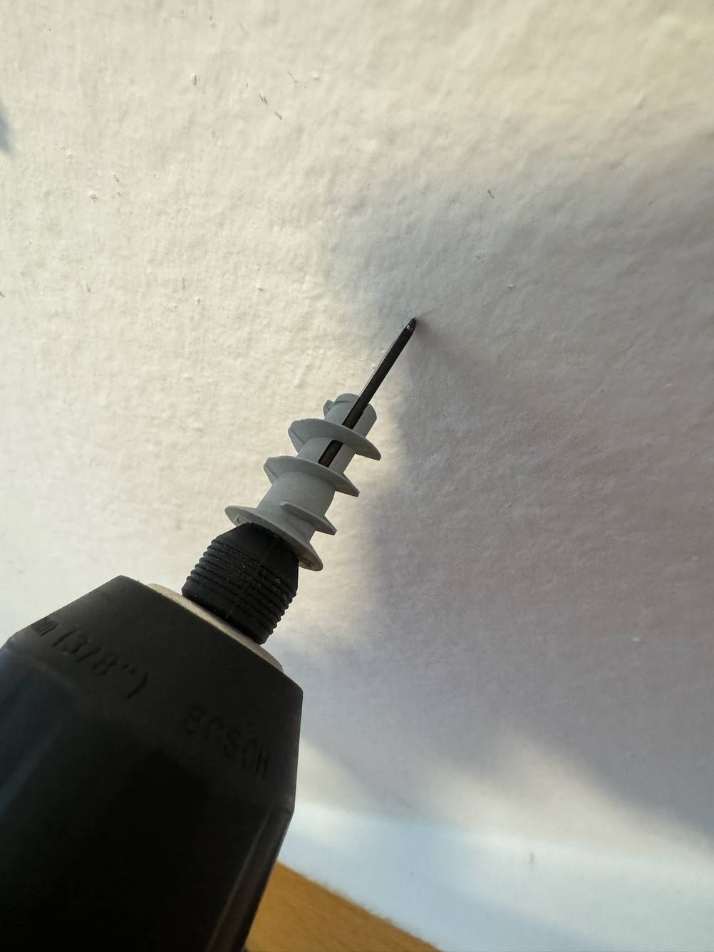 Hohlraumdübel im Test: Ein Dübel wird mit einer Maschine eingedreht.