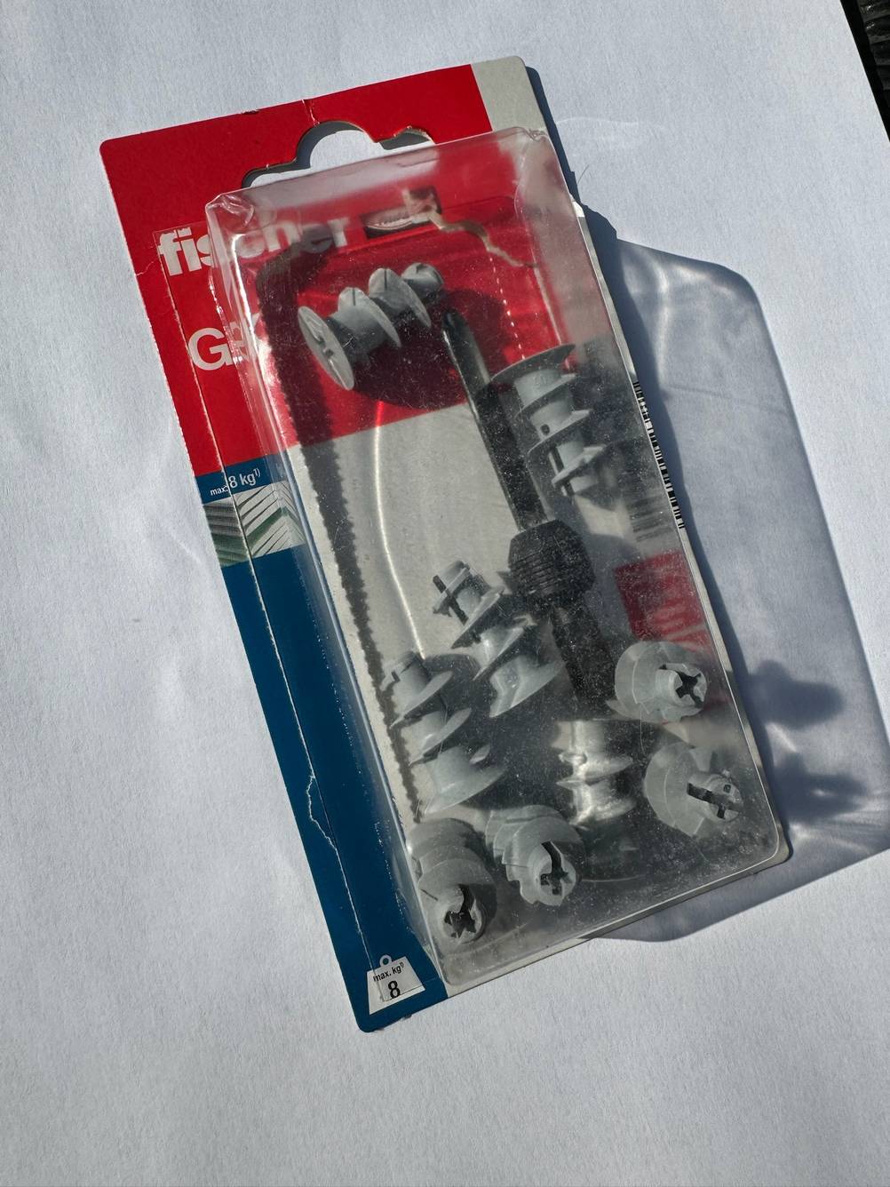 Hohlraumdübel im Test: Eine Packung Hohlraumdübel auf einer hellen Fläche von oben.