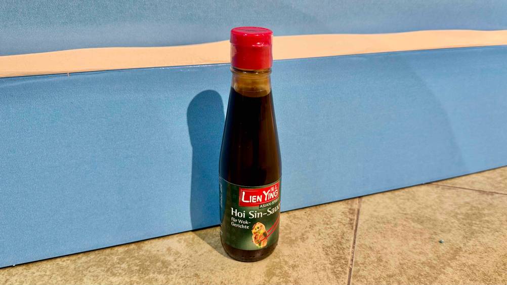 Eine Flasche der getesteten Hoisin-Sauce vor einer blauen Wand.