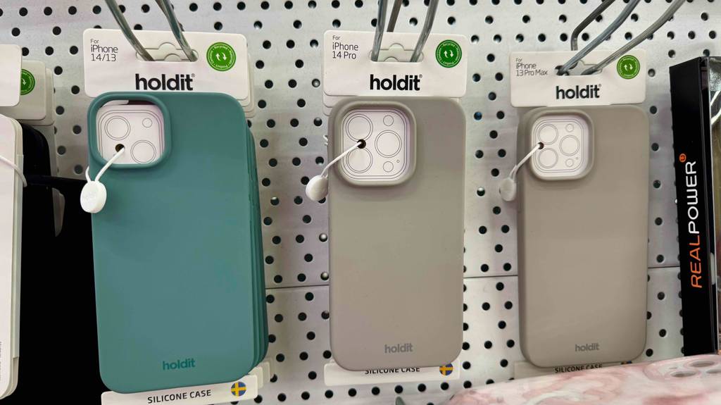 iPhone-14-Pro-Hüllen-Test: Mehrere farbige Hüllen der Marke Holdit hängen nebeneinander an einem Verkaufsregal.