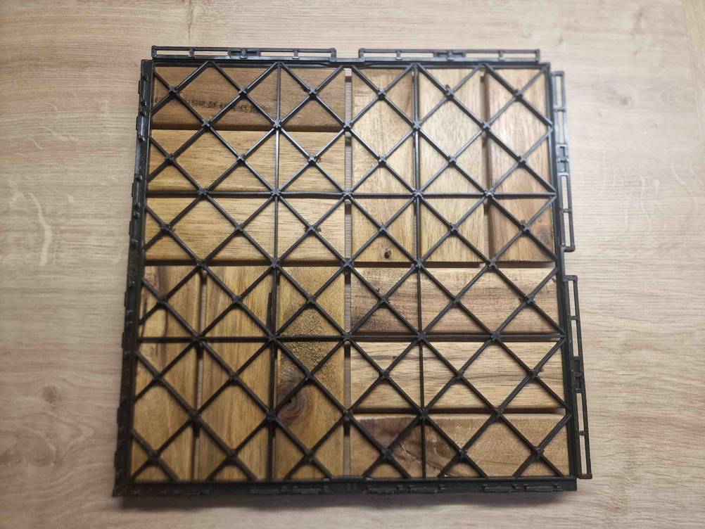 Rückseite einer getesteten Holzfliese für den Balkon auf einer Holzfläche.