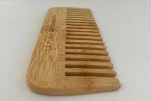 Ein Holzkamm im Test liegt auf einer weißen Oberfläche.