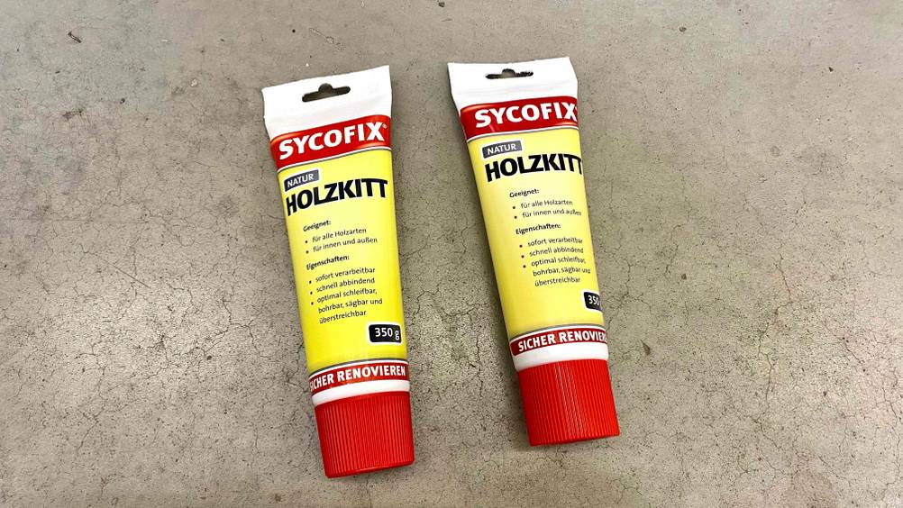 Holzkitt getestet: Zwei Tuben auf einem Betonboden.