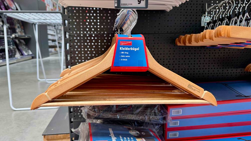 Mehrere der Holzkleiderbügel im Test in einem Verkaufsregal hängend.