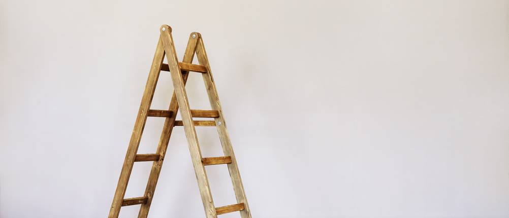 eine Holzleiter vor einer Wand