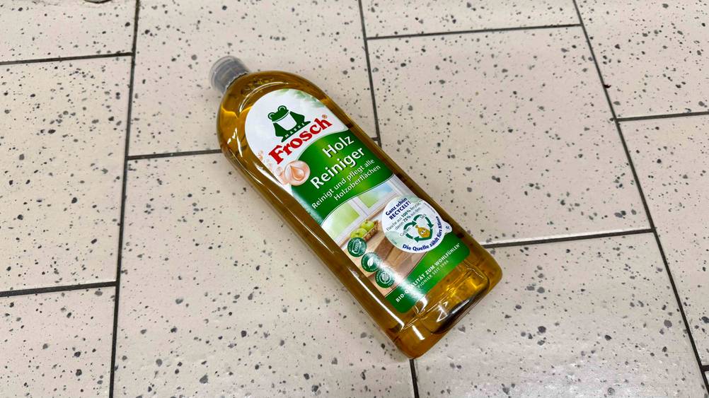 Holzreiniger im Test: Eine Flasche liegt auf einem hellen Boden.