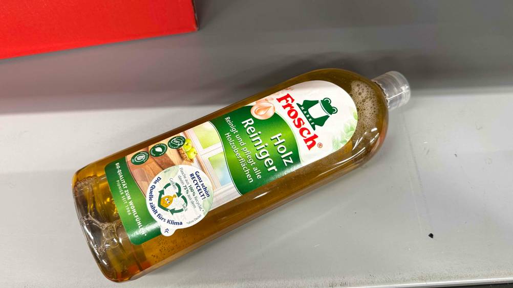 Eine Flasche des getesteten Holzreinigers horizontal von oben auf einer hellen Fläche.