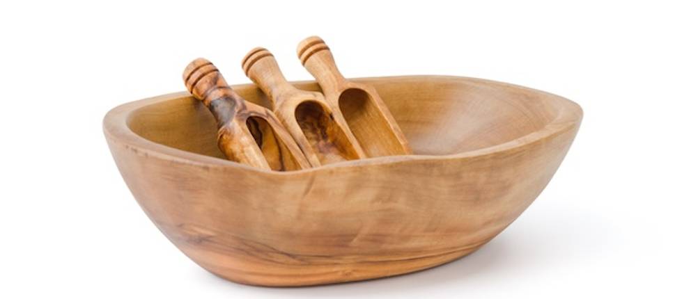 Olivenholz-Schale im Test: Vor einem weißen Hintergrund steht eine ovale Holzschale mit drei kleinen Holzschäufelchen.