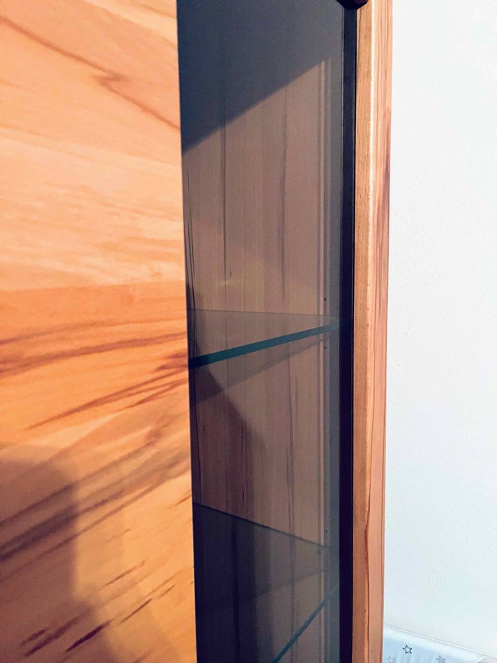 Blick auf die Einlegeböden aus Glas einer Holzvitrine im Test.