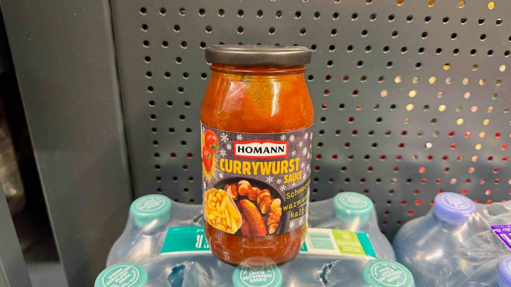 Eine getestete Currywurst-Sauce im Glas steht auf einer Packung Wasserflaschen.