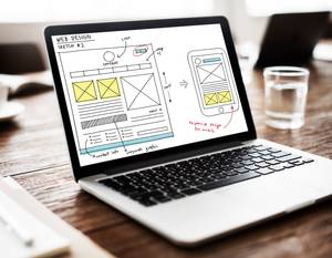 Test der Homepage-Baukästen: Auf einem Laptop ist die Skizze einer Webseite als Desktop- und Mobilversion abgebildet.