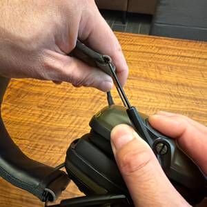 Eine Hand verlängert den Kopfbügel des Honeywell Howard Leight Impact Sport.