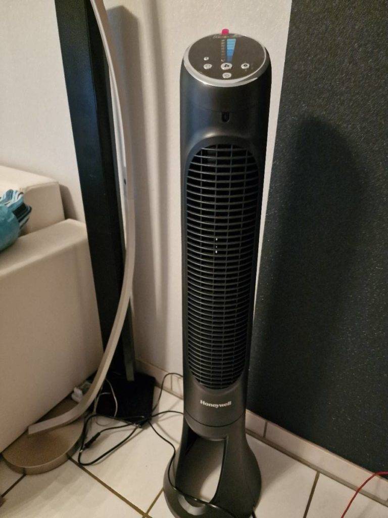 Im Test: leiser Ventilator in Schwarz der Marke Honeywell steht neben einem hellen Sofa.
