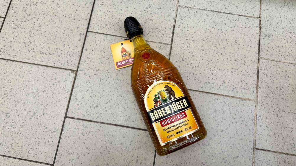 Honiglikör getestet: Eine Flasche von oben auf einem Fließenboden.