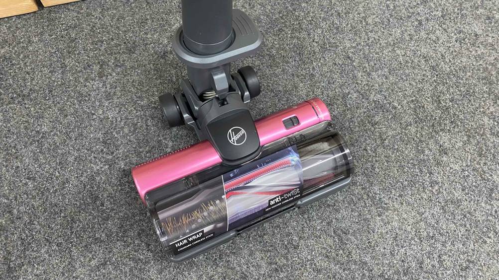 Auf dem Boden steht ein getesteter Staubsauger der Marke Hoover.