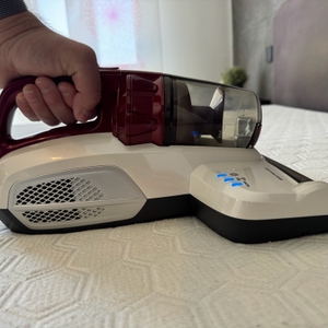 Eine Hand reinigt mit dem Hoover Ultra Vortex eine Matratze