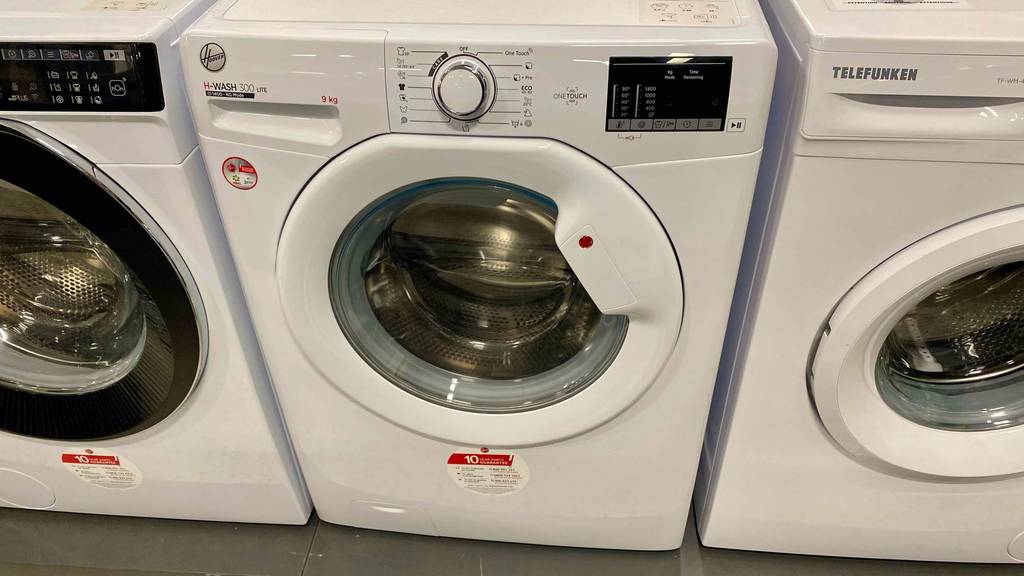 Eine Hoover-Waschmaschine in Frontansicht stehen zum testen neben anderen Waschmaschinen.