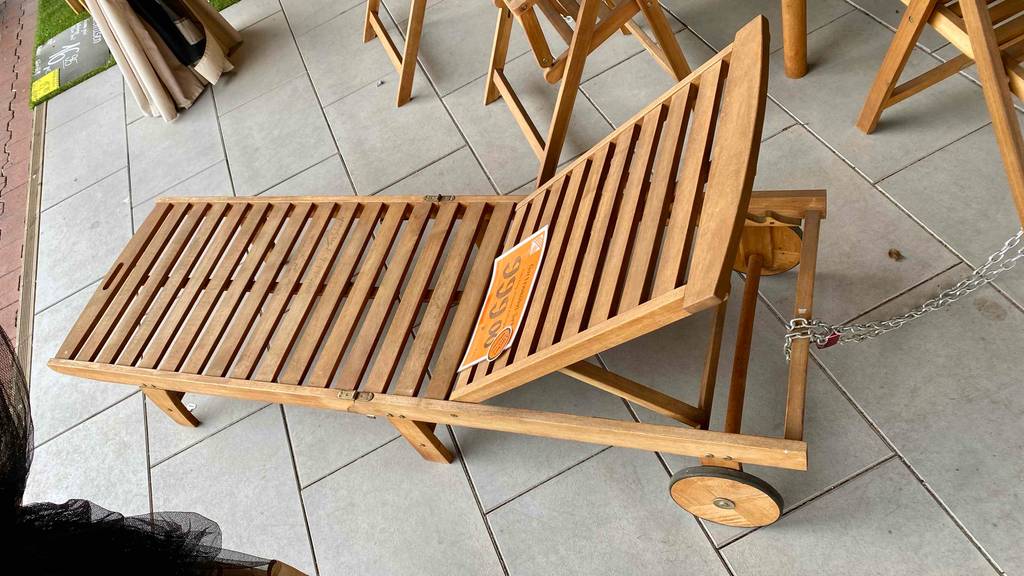 Seitenansicht von oben auf die Querverstrebungen einer Holz-Gartenliege im Test inklusive Preisschild.