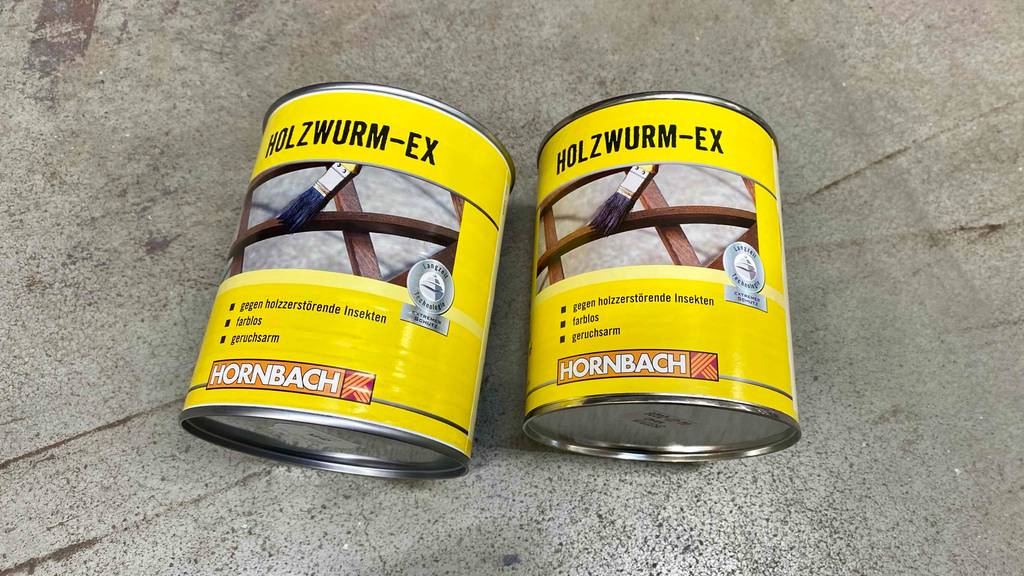 Holzwurm-Ex getestet: Zwei Dosen von Hornbach liegen nebeneinander auf einem Steinboden.