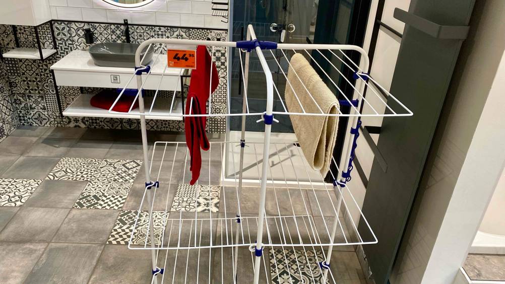 Ein getesteter Turmwäscheständer mit zwei Handtüchern und einem Preisschild in einer Ausstallung.