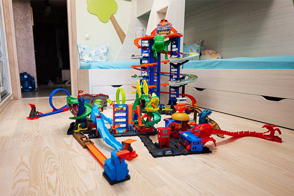 Hot-Wheels-Bahn im Test: Hier eine Dino-Bahn, die auf dem Boden eines Kinderzimmers aufgebaut ist.