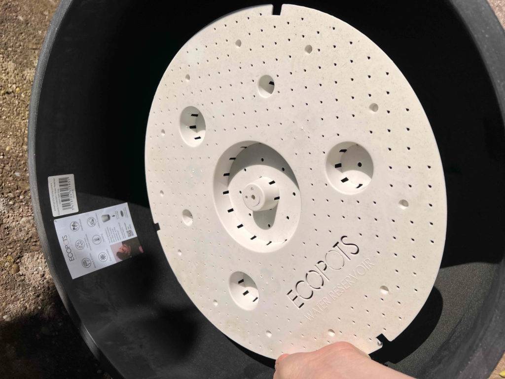 Nahaufnahme von einem schwarzen getesteten Pflanzkübel inklusive weißem Ecopots Drainage-Teller.