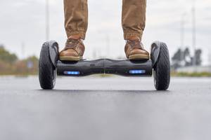 Hoverboard-Gelände-Test: Ein Mann auf einem Hoverboard in der Stadt. 