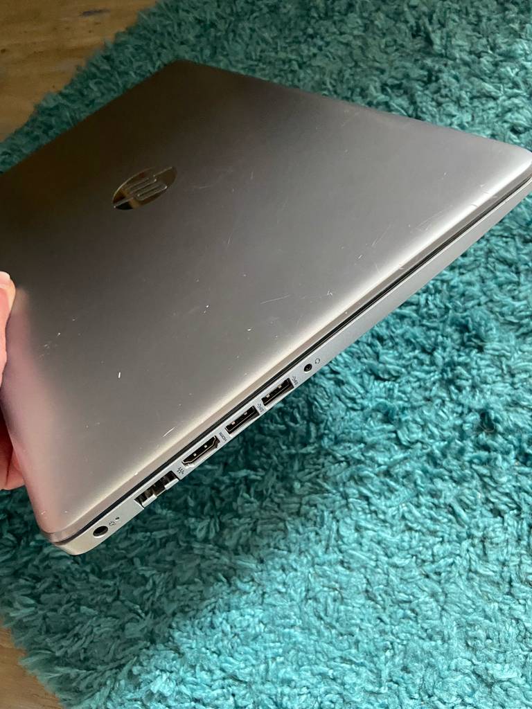 Das Windows-10-Laptop im Test befindet sich über einem türkisfarbenen Stoff, der Fokus liegt auf den Anschlüssen auf dem linken Rand.