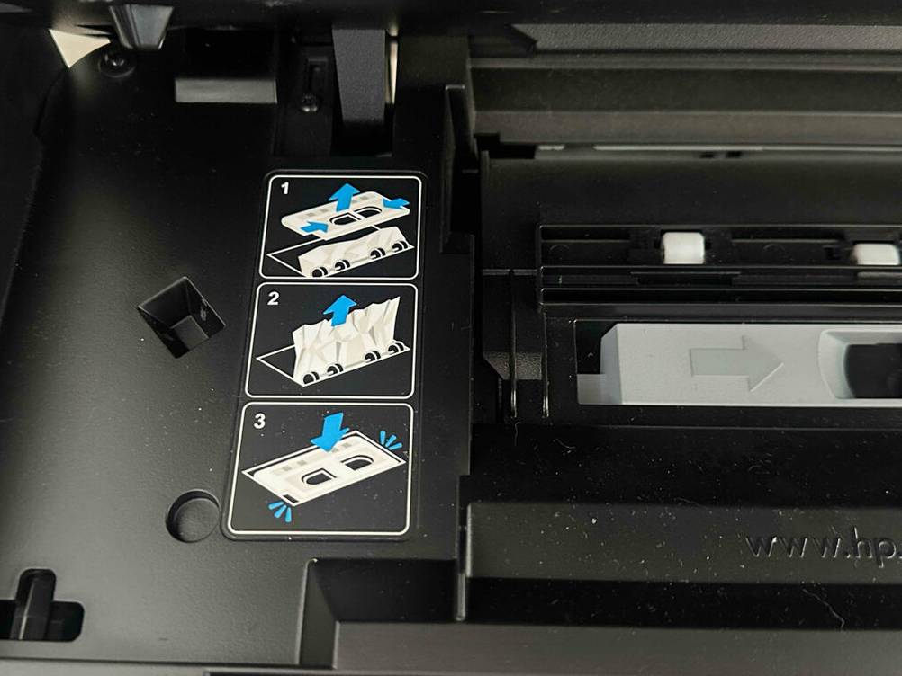 Bluetooth-Drucker-Test: Nahaufnahme der Bildbeschreibung der korrekten Papiereinfuhr eines schwarzen Druckers.