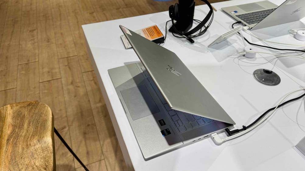 Getestet: Ein HP-Envy-Laptop halb zugeklappt von der Seite auf einer hellen Fläche stehend.