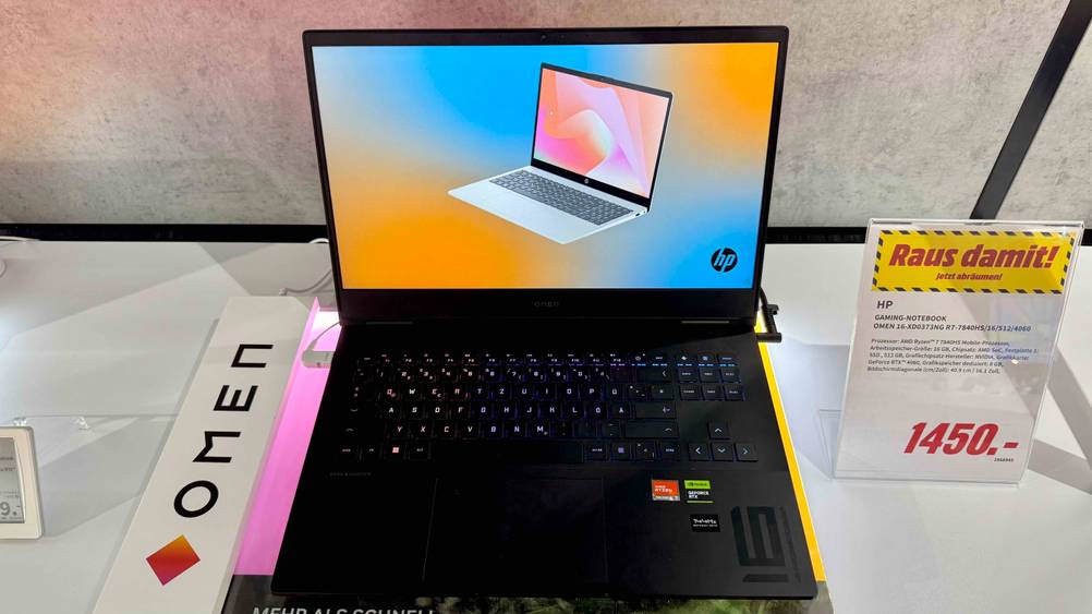 Getestet: Ein geöffnetes HP-Gaming-Laptop von vorne auf einem hellen Regal mit Preisangabe.
