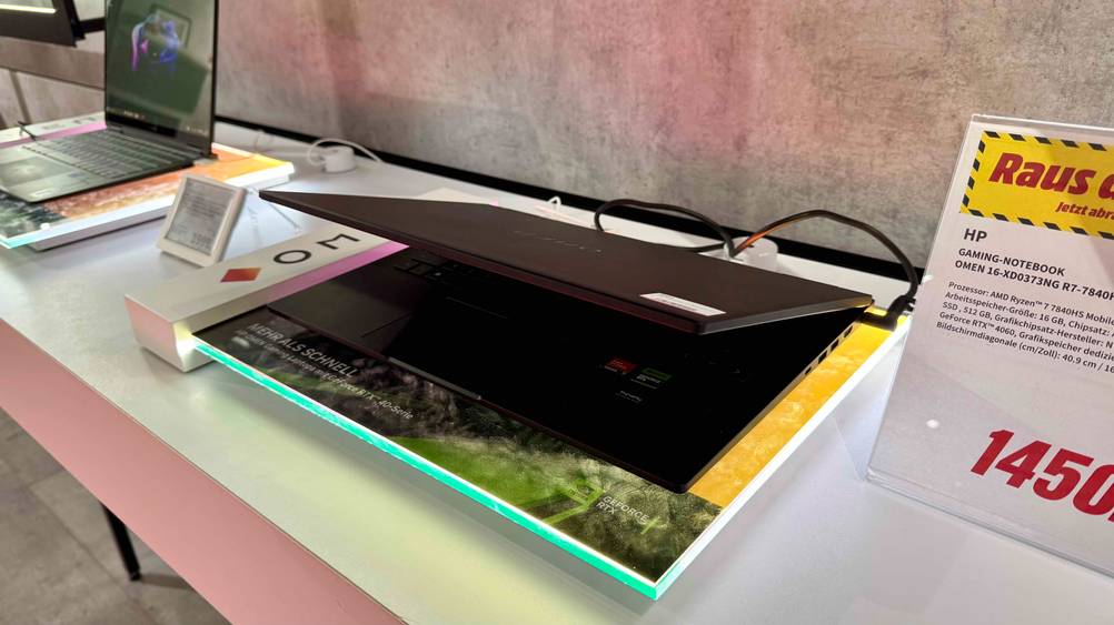 Auf einem Regal steht ein getestetes HP-Gaming-Laptop leicht geschlossen neben dem Preisschild.