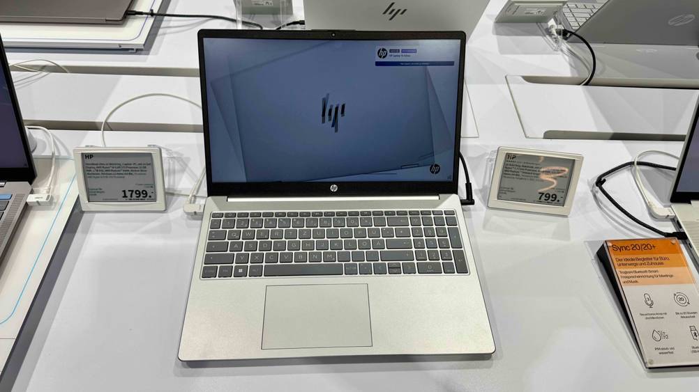 Ein aufgeklapptes HP-Laptop 15 Zoll im Test von vorne, daneben ein Preisschild.