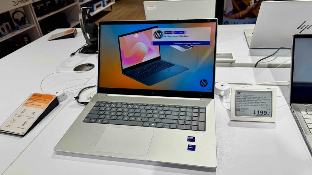 Ein aufgeklapptes HP-Laptop 17-Zoll im Test auf einer Ausstellungsfläche mit Preisangabe.