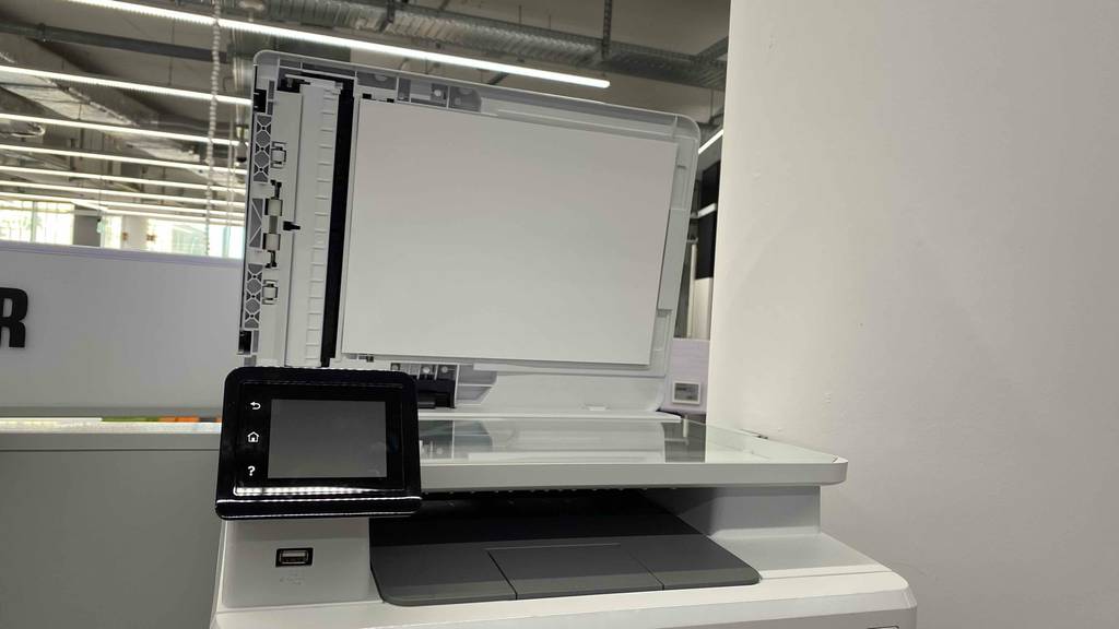 Getesteter HP Laser-Multifunktionsdrucker mit geöffnetem Deckel in Frontansicht.
